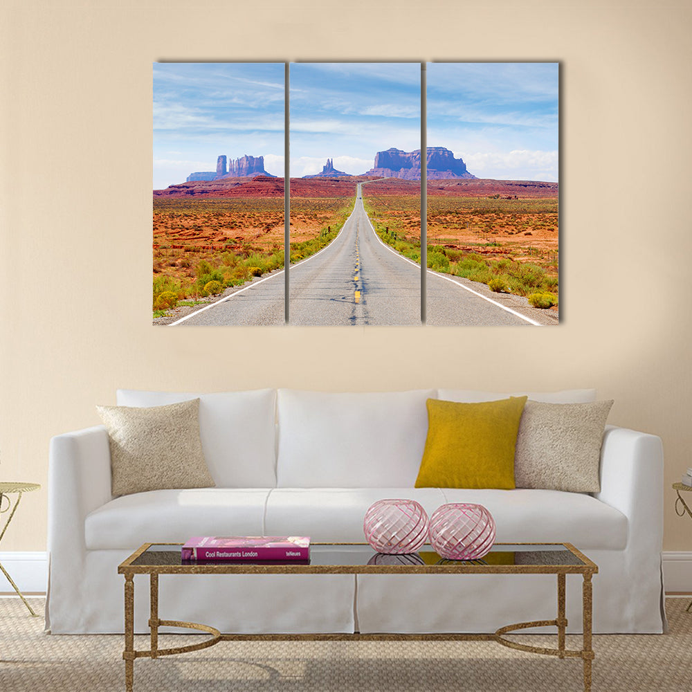 U.s. Route 163 Through Monument Valley Canvas Wall Art in gray, orange and blue, 3 panel horizontal set hung on a wall