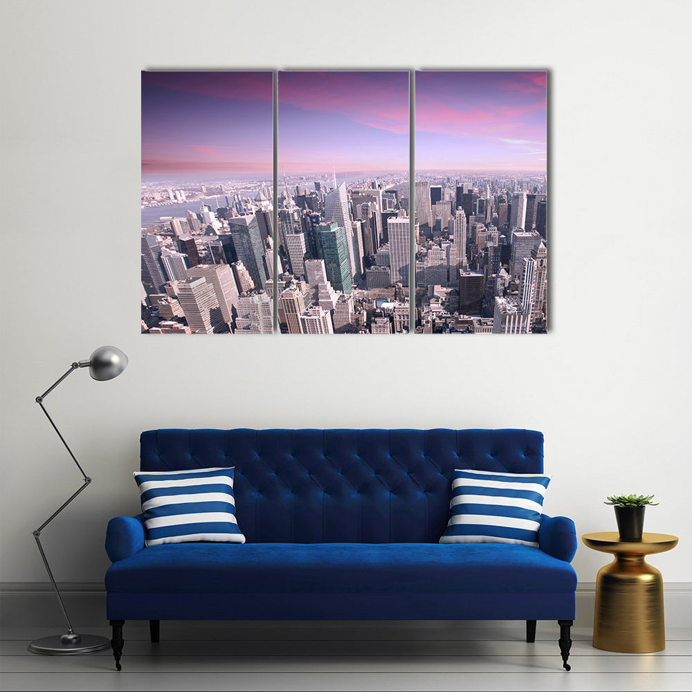 New York City Skyline at Sunset Canvas Wall Art in gray, purple and pink, 3 panel horizontal set hung on a wall