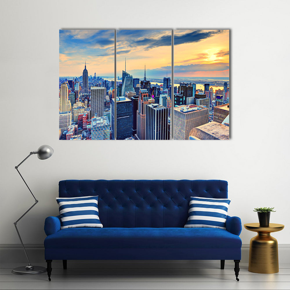 New York City Skyline at Dusk Canvas Wall Art in orange, yellow and blue, 3 panel horizontal set hung on a wall