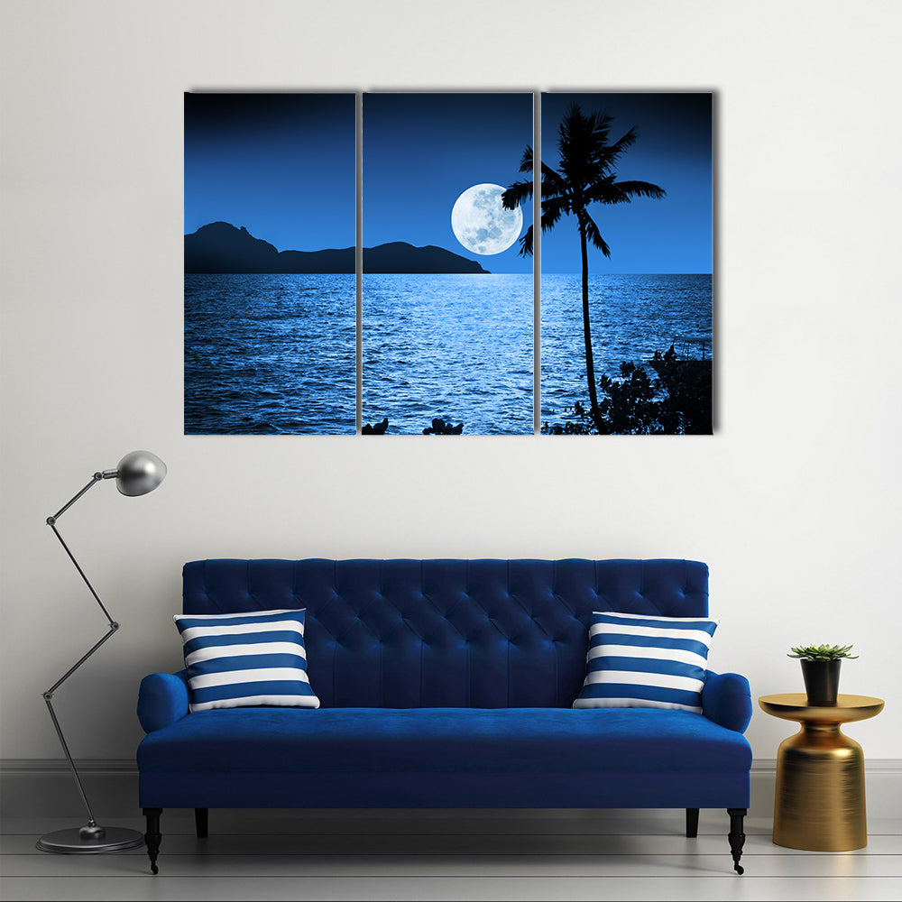 Full Moon Over Ocean Canvas Wall Art in black, white and blue, 3 panel horizontal set hung on a wall