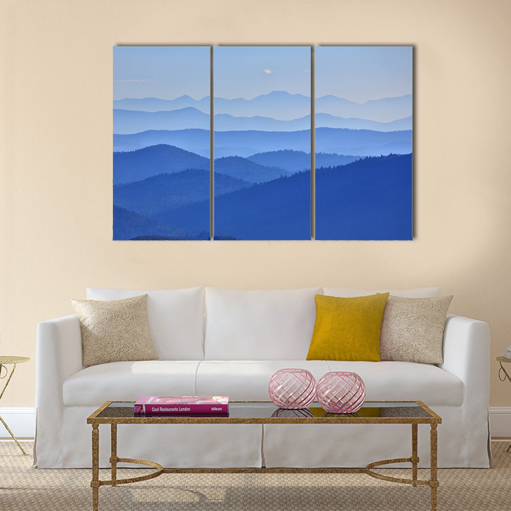 Misty Mountain Valley with Moon Canvas Wall Art in blue, 3 panel horizontal set hung on a wall