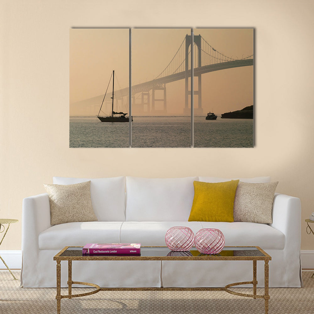 Hazy Suspension Bridge with Sailboat Canvas Wall Art in gray, beige and brown, 3 panel horizontal set hung on a wall