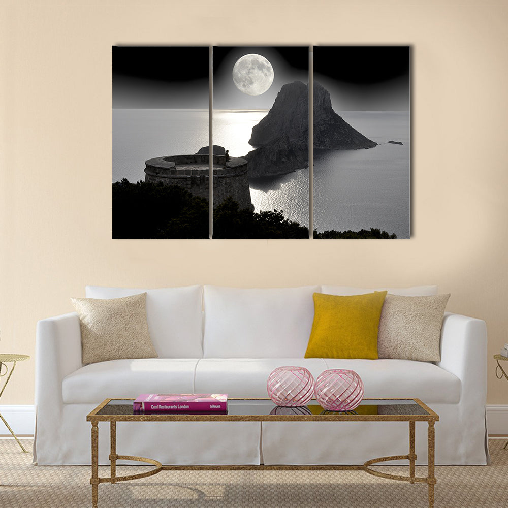 Moonlit Watchtower on Rocky Island Canvas Wall Art in black, white and gray, 3 panel horizontal set hung on a wall