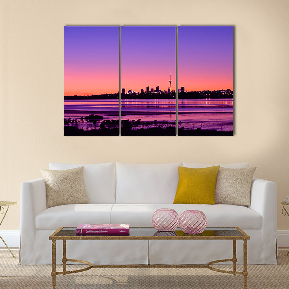 Auckland City Sunrise Canvas Wall Art in orange, purple and pink, 3 panel horizontal set hung on a wall