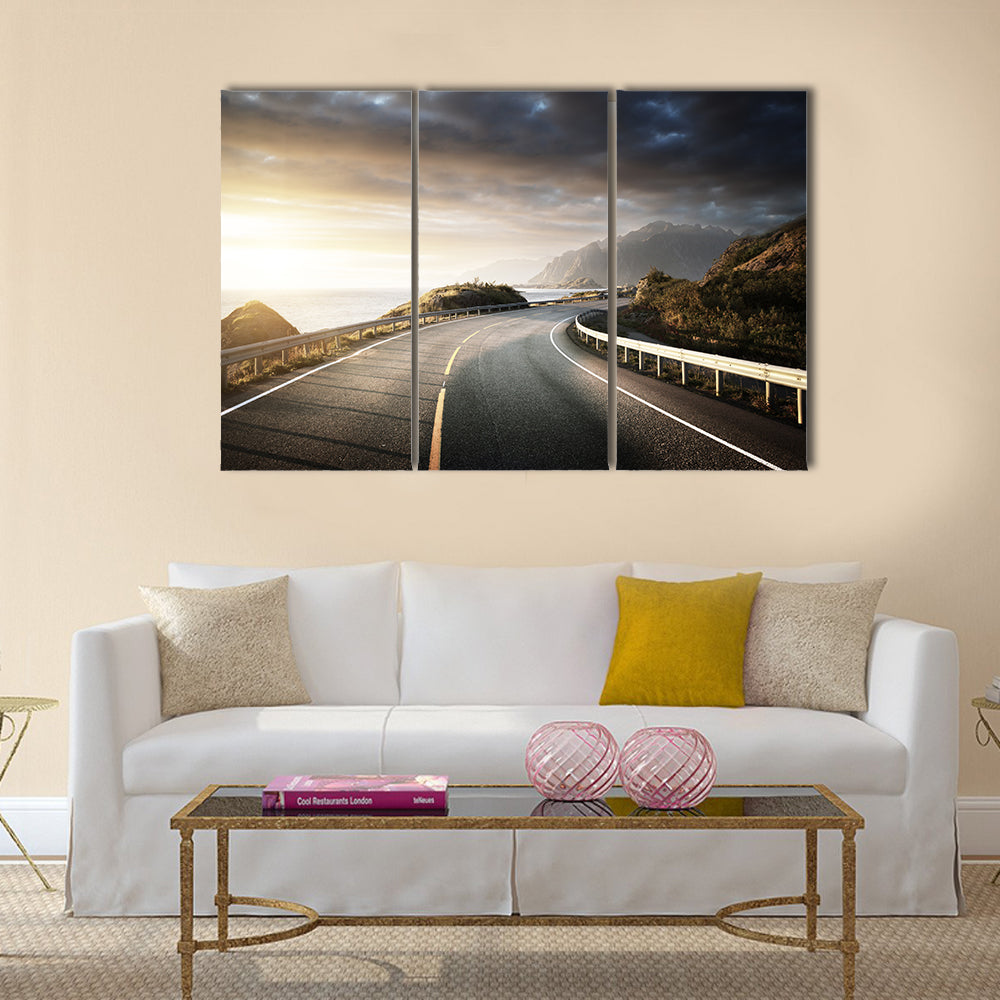 Winding Coastal Road in Lofoten Canvas Wall Art in gray, yellow and blue, 3 panel horizontal set hung on a wall
