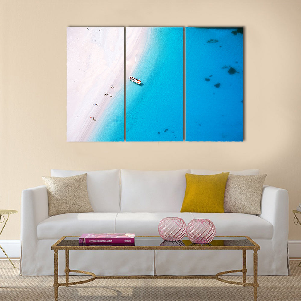 Aerial Beach on Zakynthos Island Canvas Wall Art in white and blue, 3 panel horizontal set hung on a wall