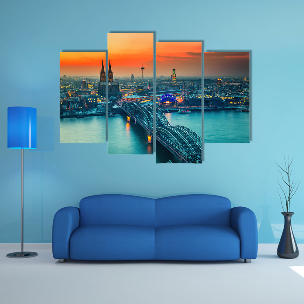 Cologne Cathedral And Hohenzollern Bridge At Night In Germany Canvas Wall Art in gray, orange and yellow, 4 panel Pop layout hung on a wall