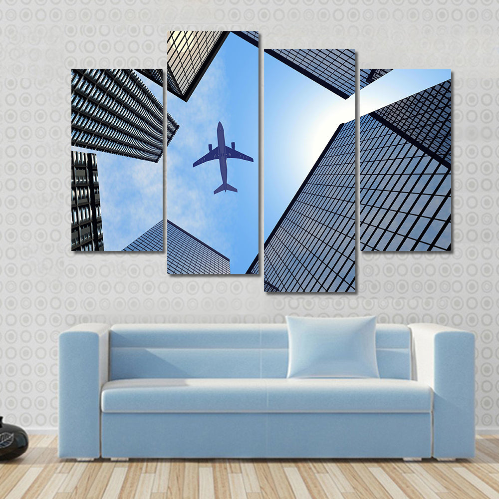 Airplane Above Buildings Canvas Wall Art