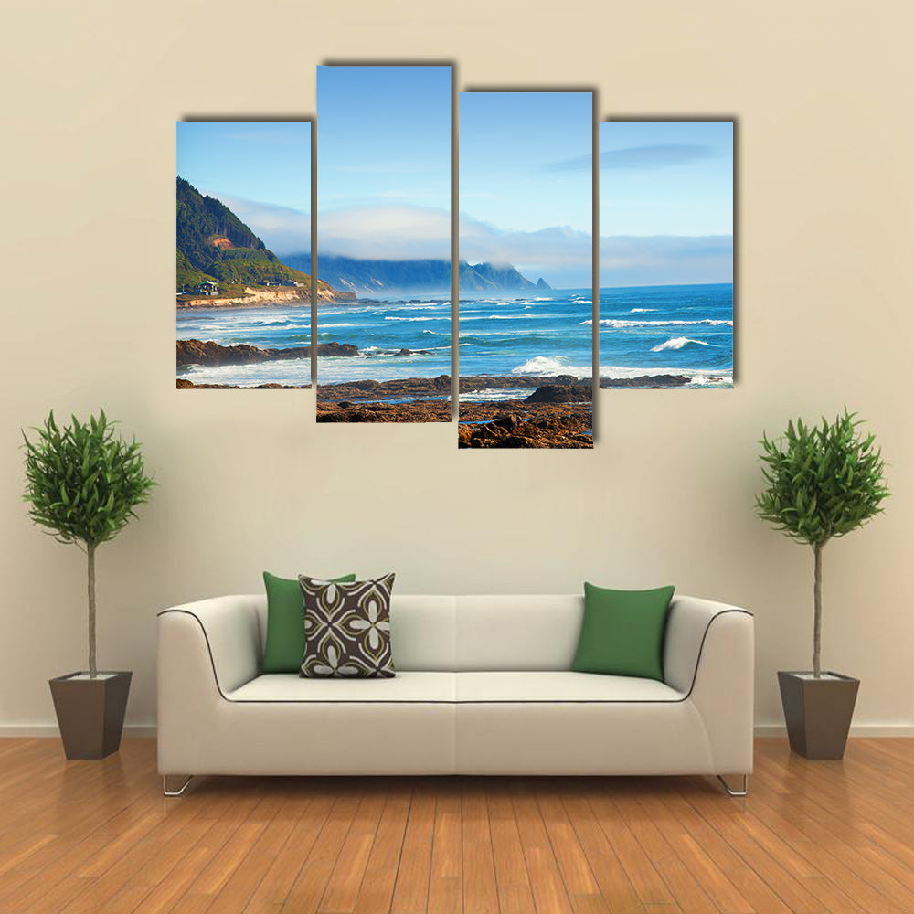 Rocky Shoreline with Crashing Waves and Misty Coastal Hills Canvas Wall Art