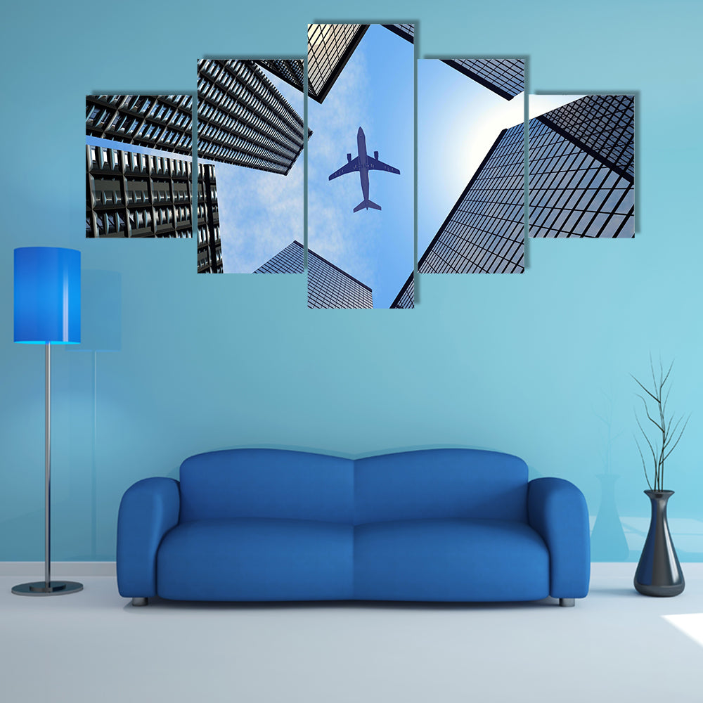 Airplane Above Buildings Canvas Wall Art