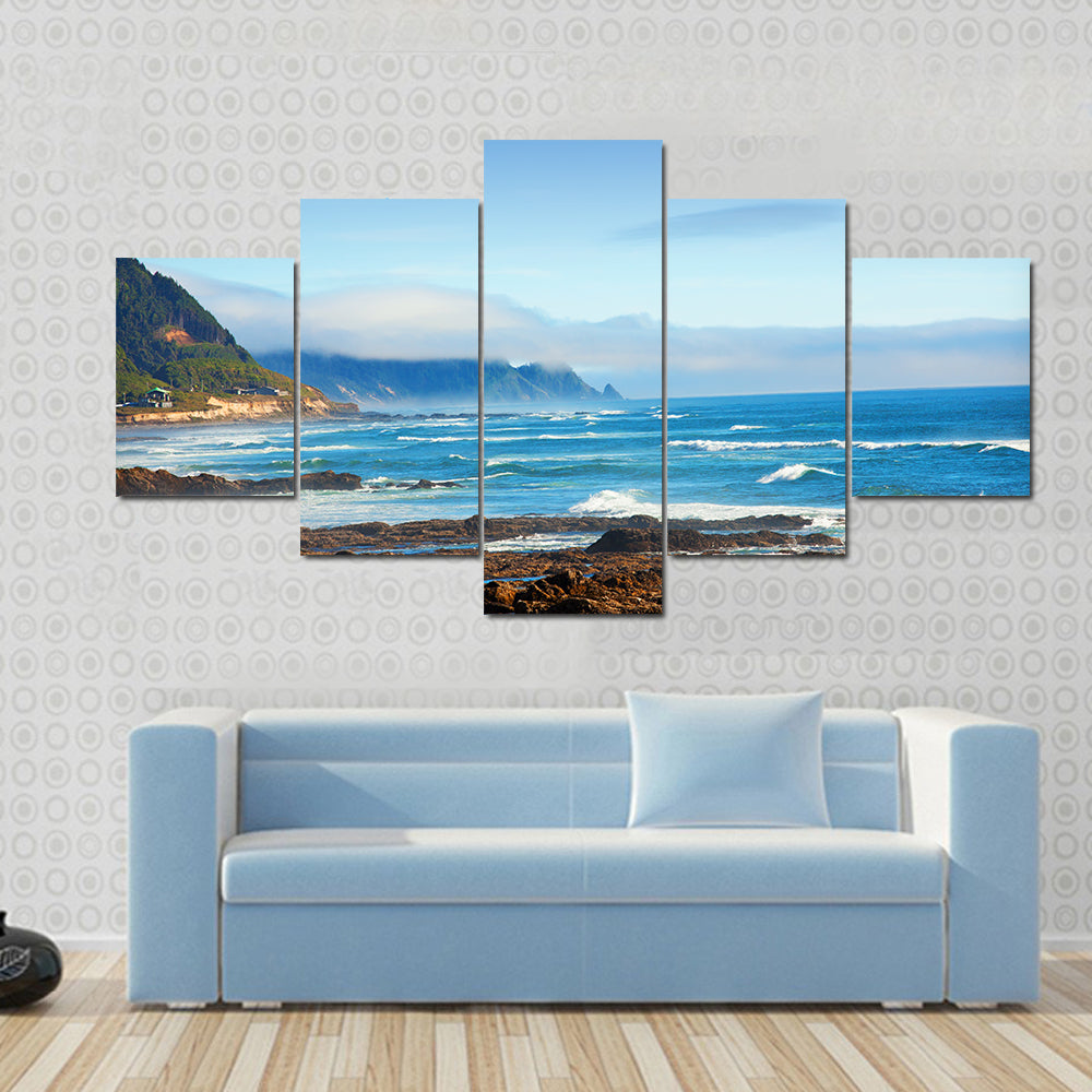 Rocky Shoreline with Crashing Waves and Misty Coastal Hills Canvas Wall Art