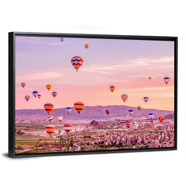 Hot Air balloons Flying Over Rock Landscape At Cappadocia Canvas Wall Art in orange, purple and pink, framed canvas, product view on a white background