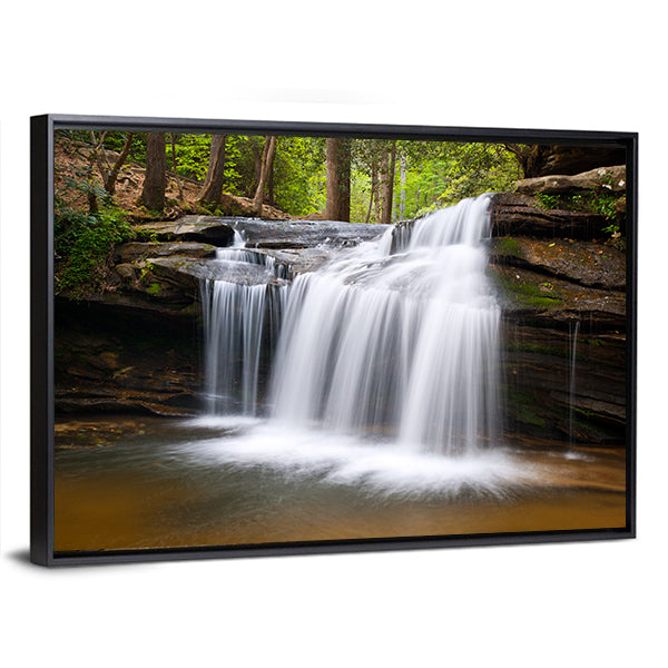 Cascading Forest Waterfall Over Layered Rocks Canvas Wall Art in white, brown and green, framed canvas, product view on a white background