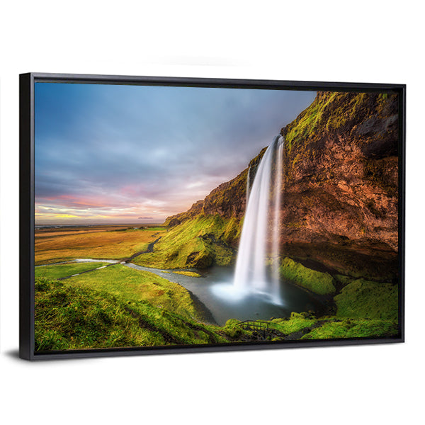 Seljalandsfoss Waterfall At Sunset In Iceland Canvas Wall Art in orange, green and blue, framed canvas, product view on a white background