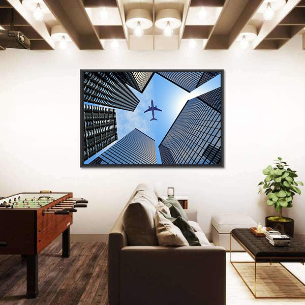 Airplane Above Buildings Canvas Wall Art