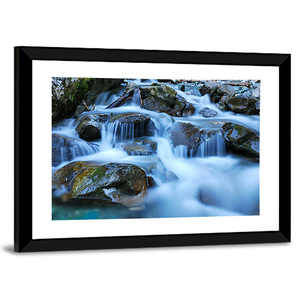River Through Mossy Stones in Cadore Canvas Wall Art in gray, brown and blue, framed print, product view on a white background