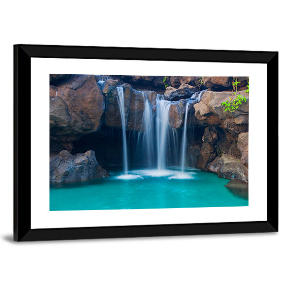 Waterfall Into Hotel Pool In Hawaii Canvas Wall Art in white, brown and blue, framed print, product view on a white background