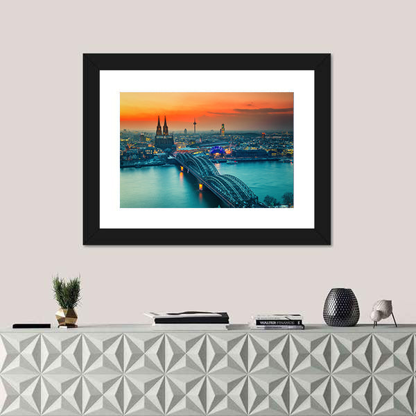 Cologne Cathedral And Hohenzollern Bridge At Night In Germany Canvas Wall Art in gray, orange and yellow, framed print shown in a room