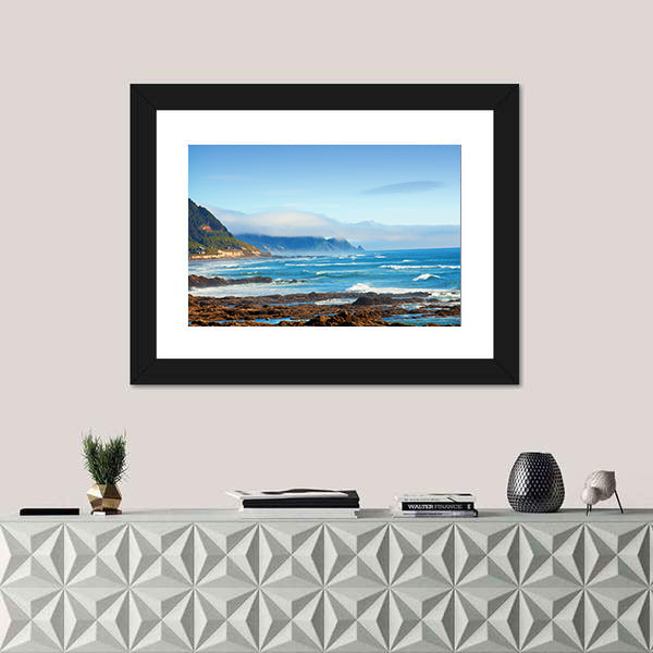 Rocky Shoreline with Crashing Waves and Misty Coastal Hills Canvas Wall Art