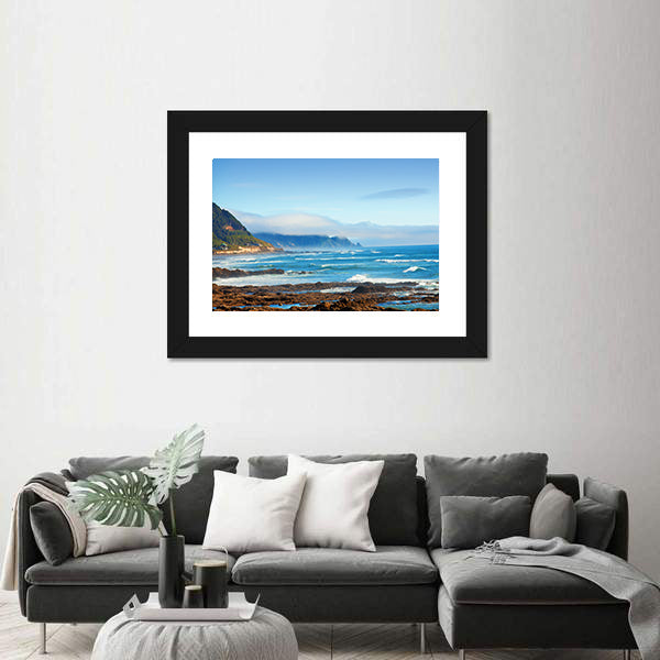 Rocky Shoreline with Crashing Waves and Misty Coastal Hills Canvas Wall Art