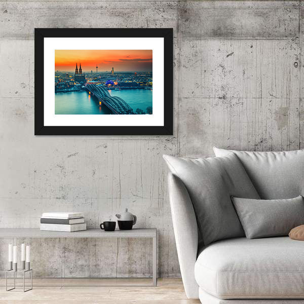 Cologne Cathedral And Hohenzollern Bridge At Night In Germany Canvas Wall Art in gray, orange and yellow, framed print shown in a room