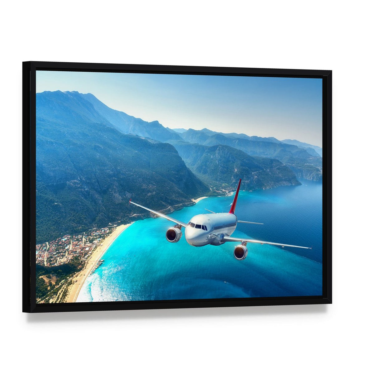 Commercial Airplane Over Ocean Coastline Canvas Wall Art, framed canvas in a black floater frame, angled product view