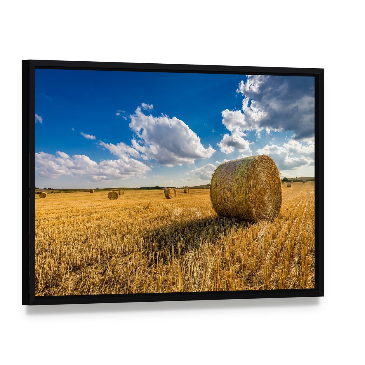 Yellow Hay Bale in a Summer Field Canvas Wall Art, framed canvas in a black floater frame, angled product view