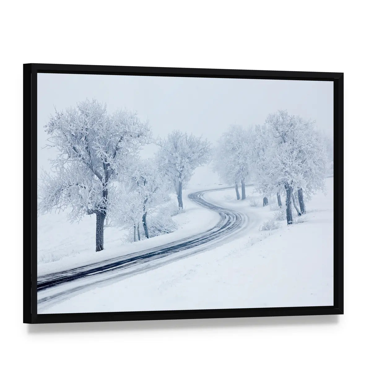 Snowy Winter Road Canvas Wall Art, framed canvas in a black floater frame, angled product view