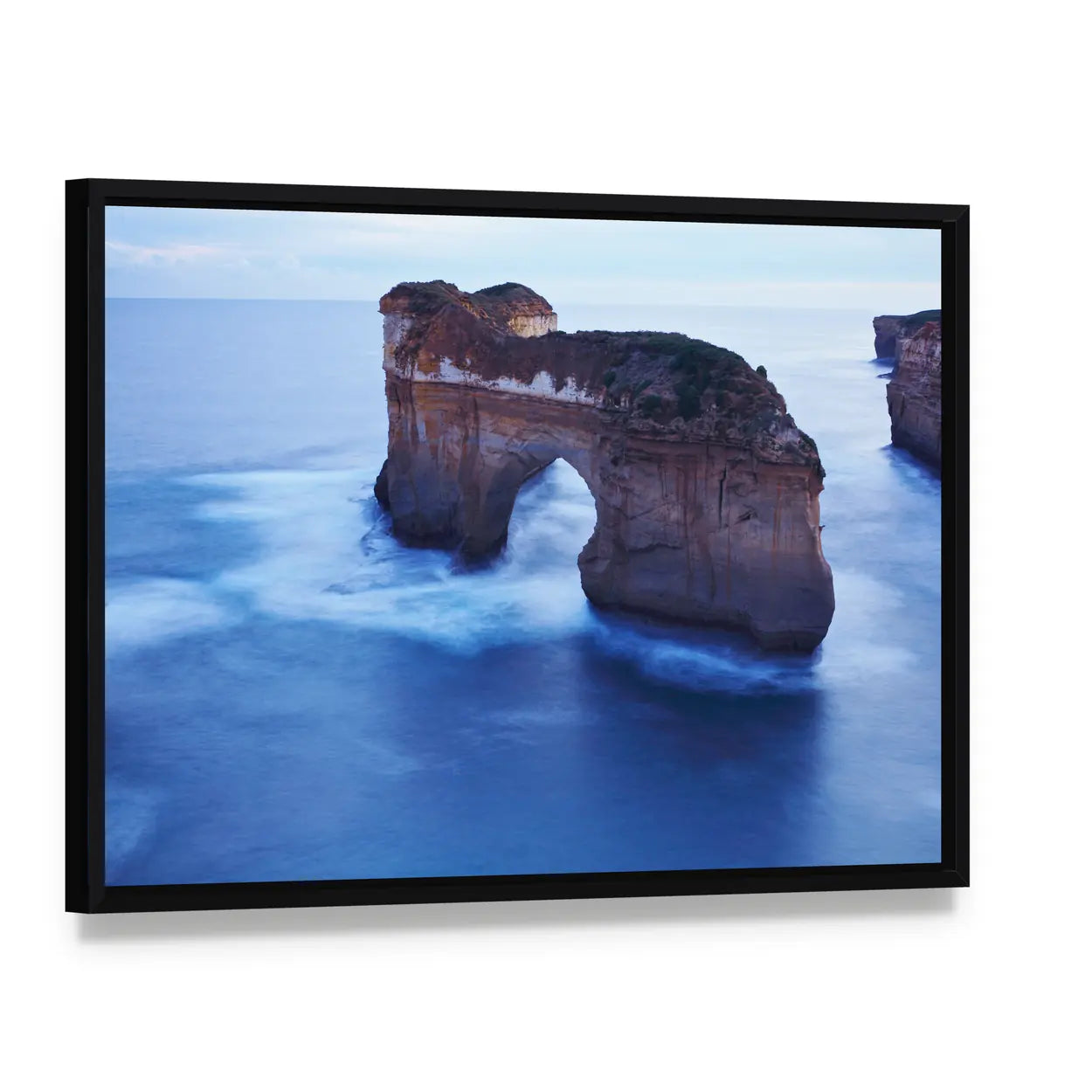 Misty Sea Arch and Limestone Cliffs Canvas Wall Art, framed canvas in a black floater frame, angled product view