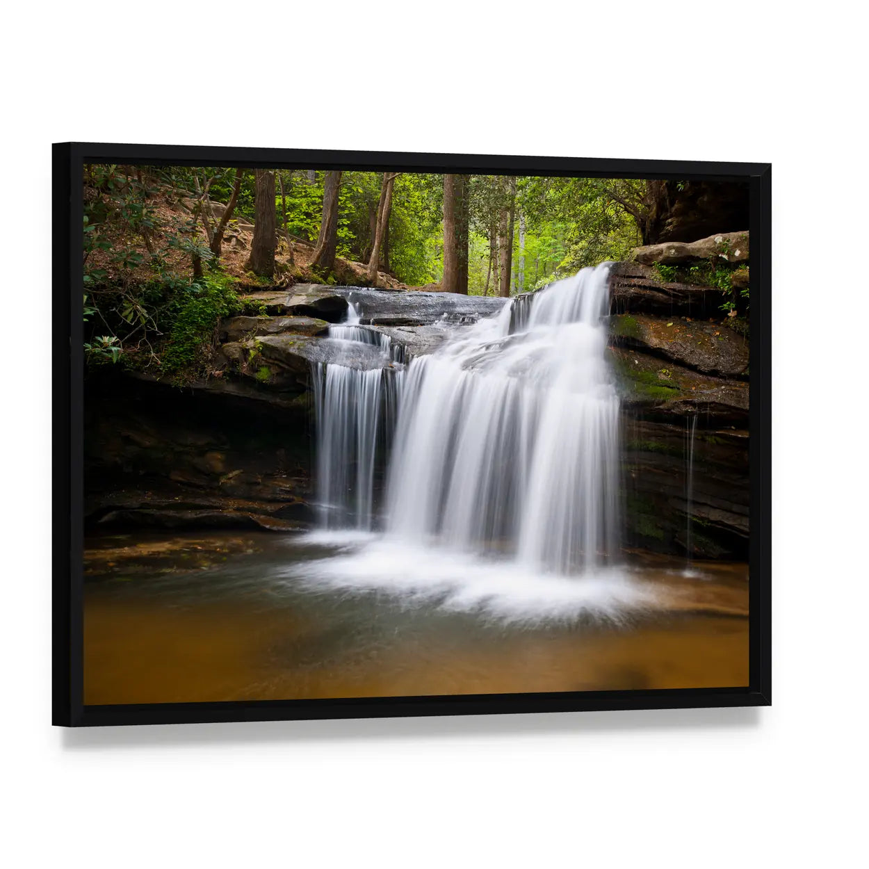 Cascading Forest Waterfall Over Layered Rocks Canvas Wall Art, framed canvas in a black floater frame, angled product view