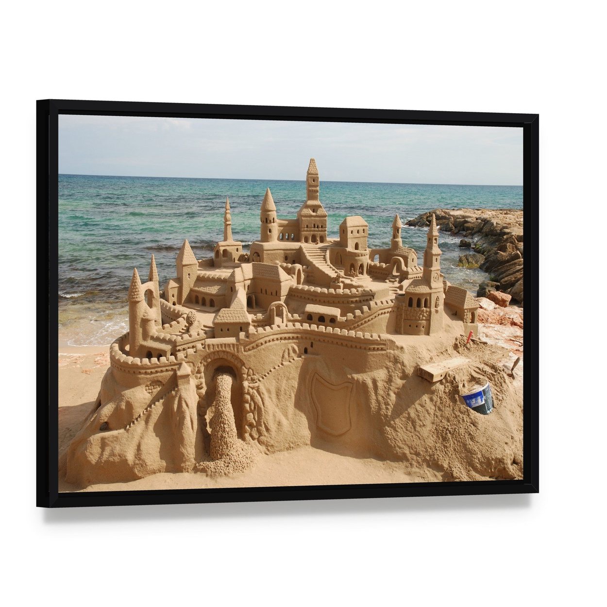 Sandcastle on Mediterranean Beach Canvas Wall Art, framed canvas in a black floater frame, angled product view