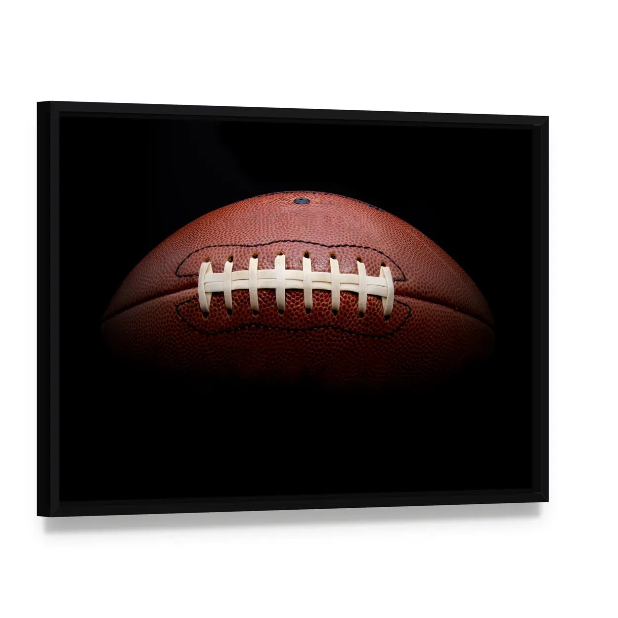 American Football Close-up with White Laces Canvas Wall Art, framed canvas in a black floater frame, angled product view