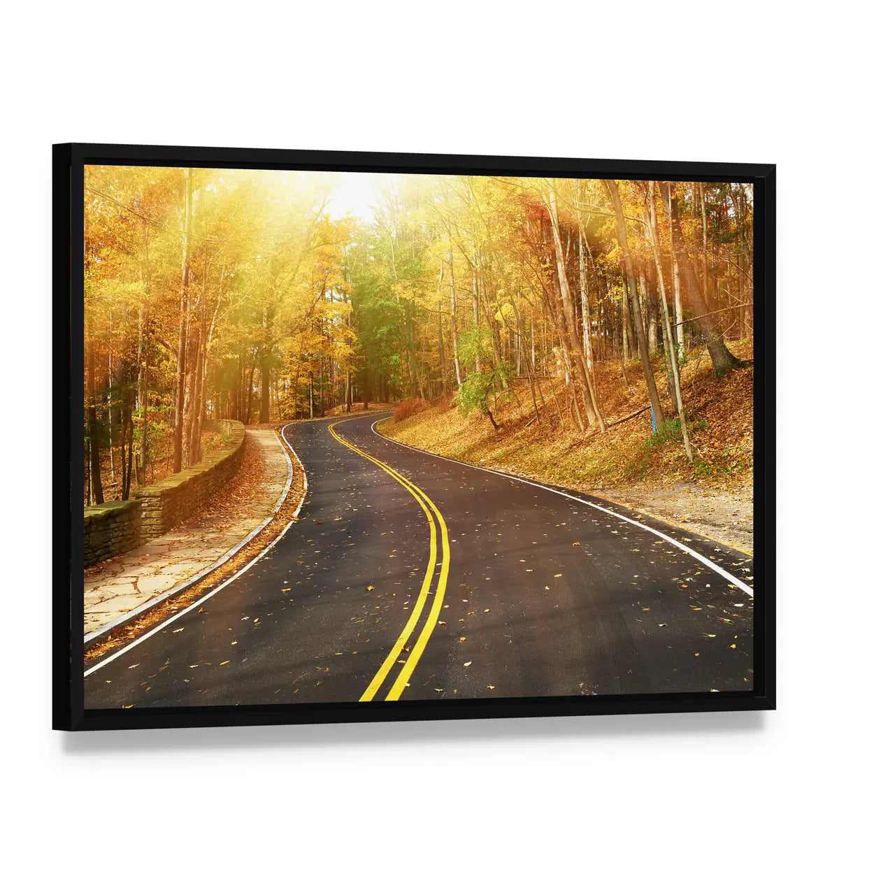 Autumn Road Through Sunlit Trees Canvas Wall Art, framed canvas in a black floater frame, angled product view