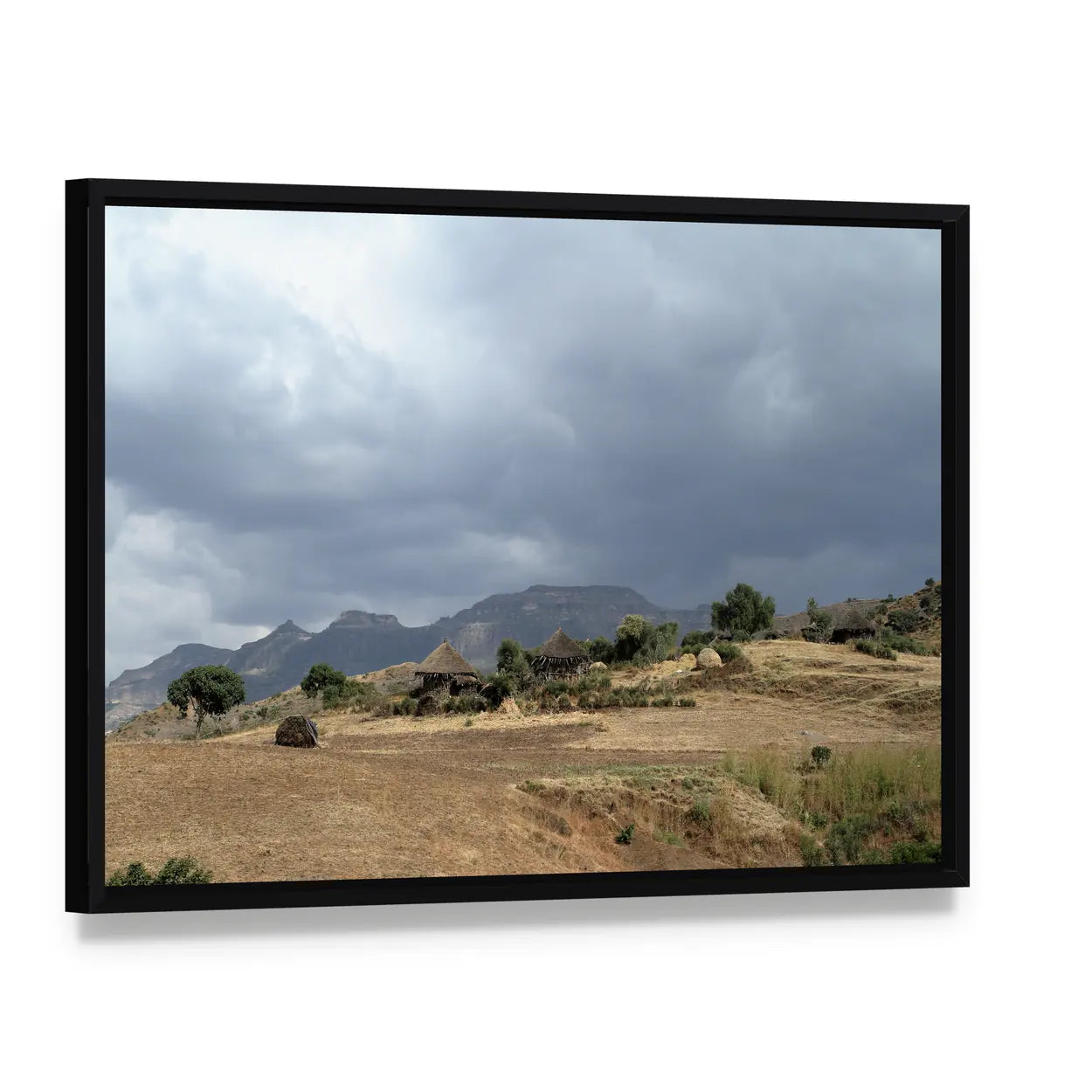 Thatched Huts in Rural Africa Canvas Wall Art, framed canvas in a black floater frame, angled product view