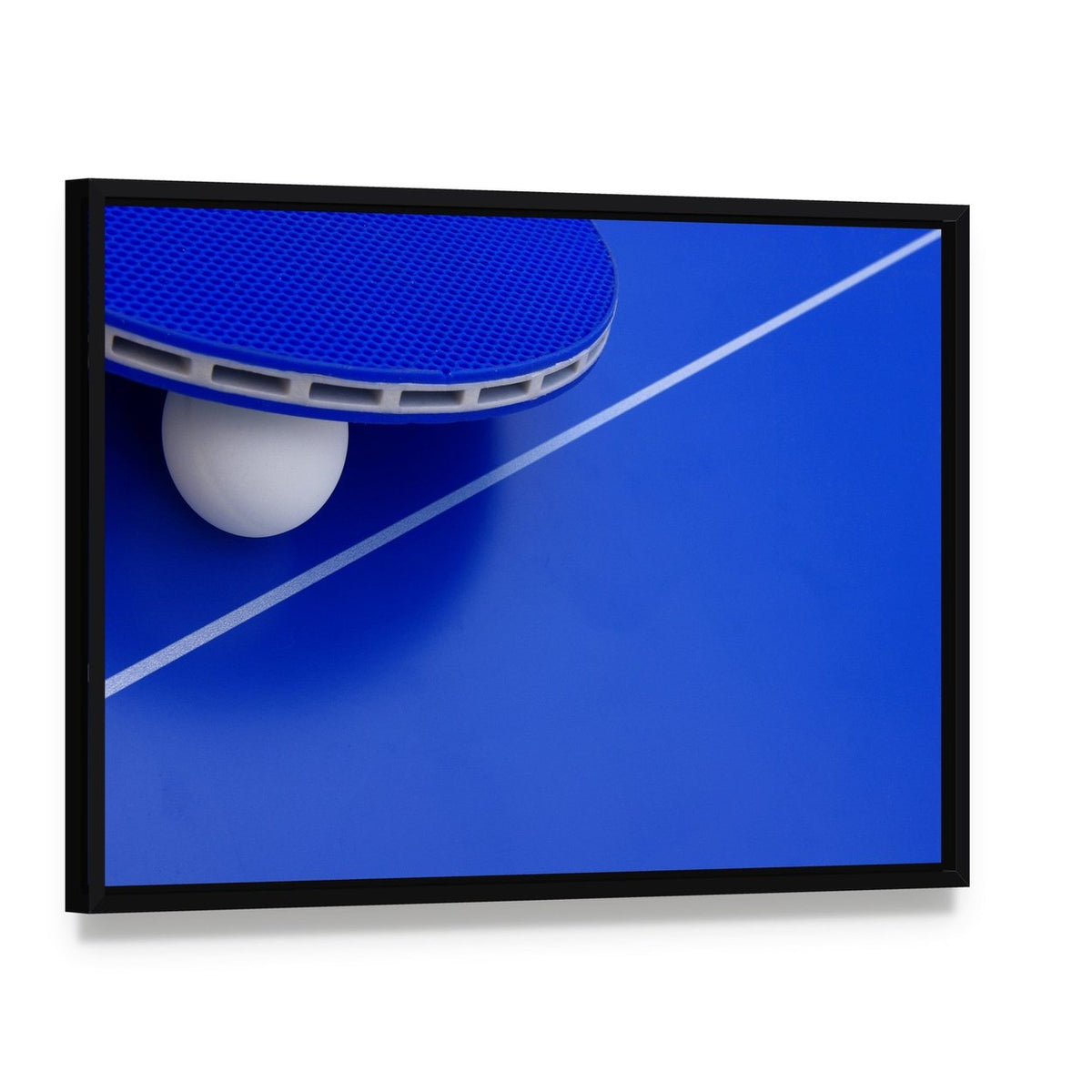 Ping Pong Ball and Racket on Table Canvas Wall Art, framed canvas in a black floater frame, angled product view