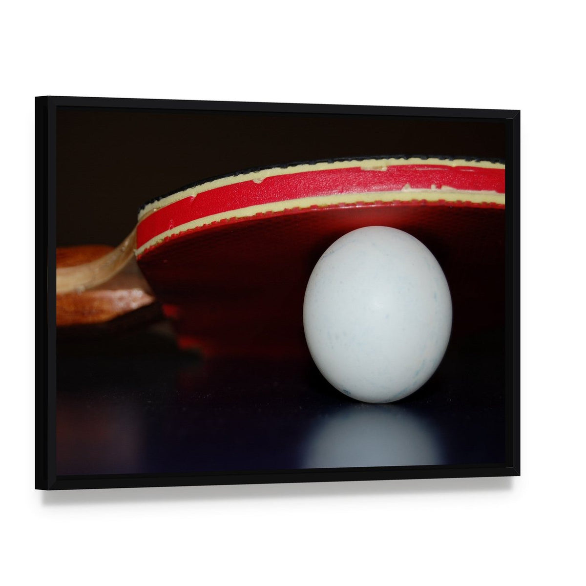 Table Tennis Paddle and Ball Canvas Wall Art, framed canvas in a black floater frame, angled product view