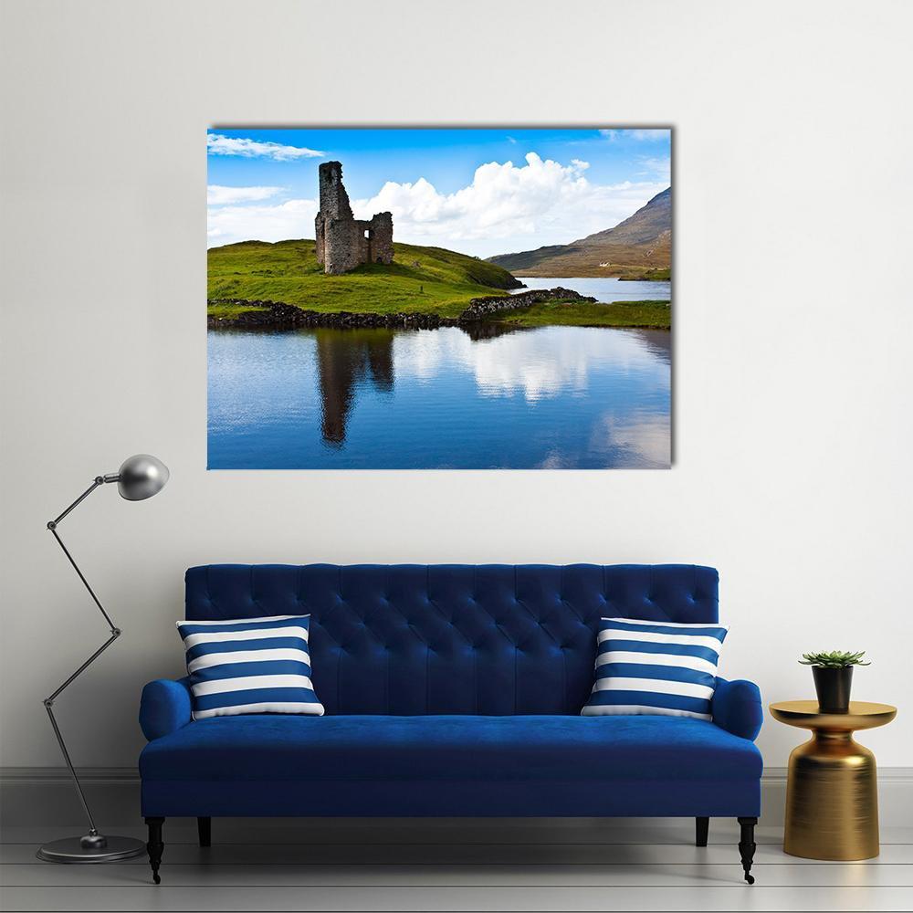 Path to Castle Ruin by Reflective Lake Canvas Wall Art in gray, green and blue, single panel hung on a wall