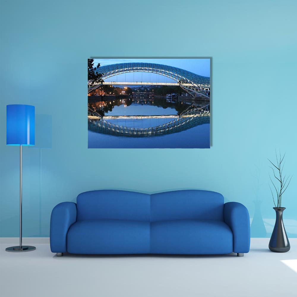 Led-lit Pedestrian Bridge at Twilight Canvas Wall Art in black and blue, single panel hung on a wall