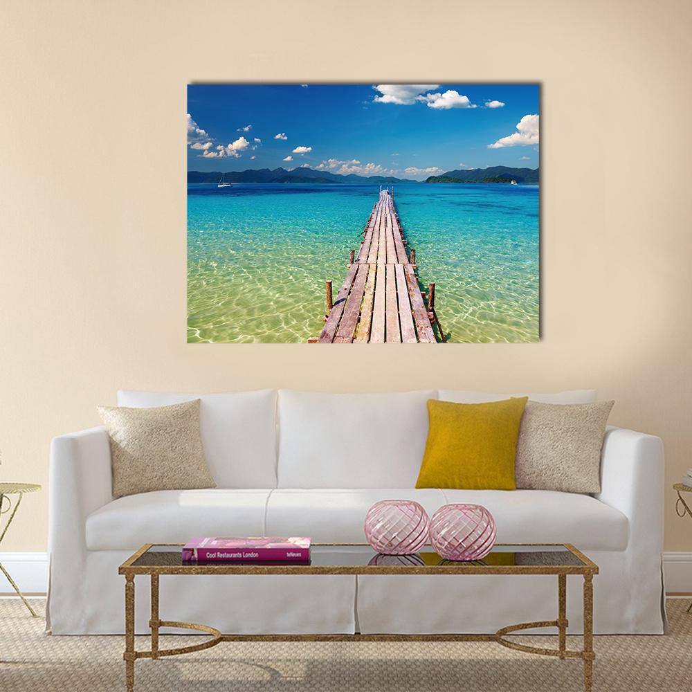 Weathered Wooden Pier Over Turquoise Water Canvas Wall Art in brown, green and blue, single panel hung on a wall