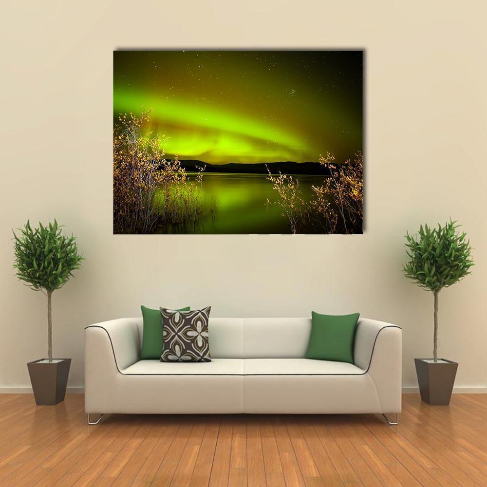 Northern Lights Over Lake Canvas Wall Art in black and green, single panel hung on a wall