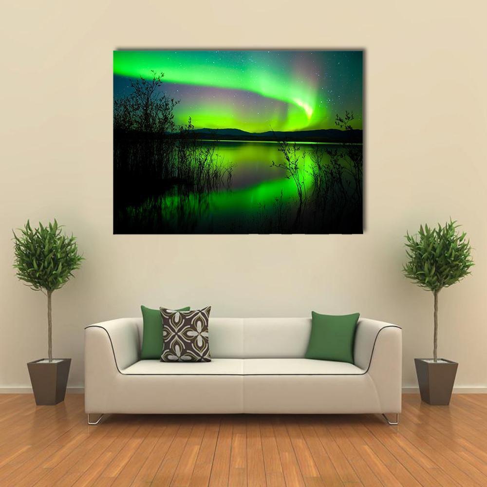 Aurora Borealis Over Reflective Lake Canvas Wall Art in black and green, single panel hung on a wall