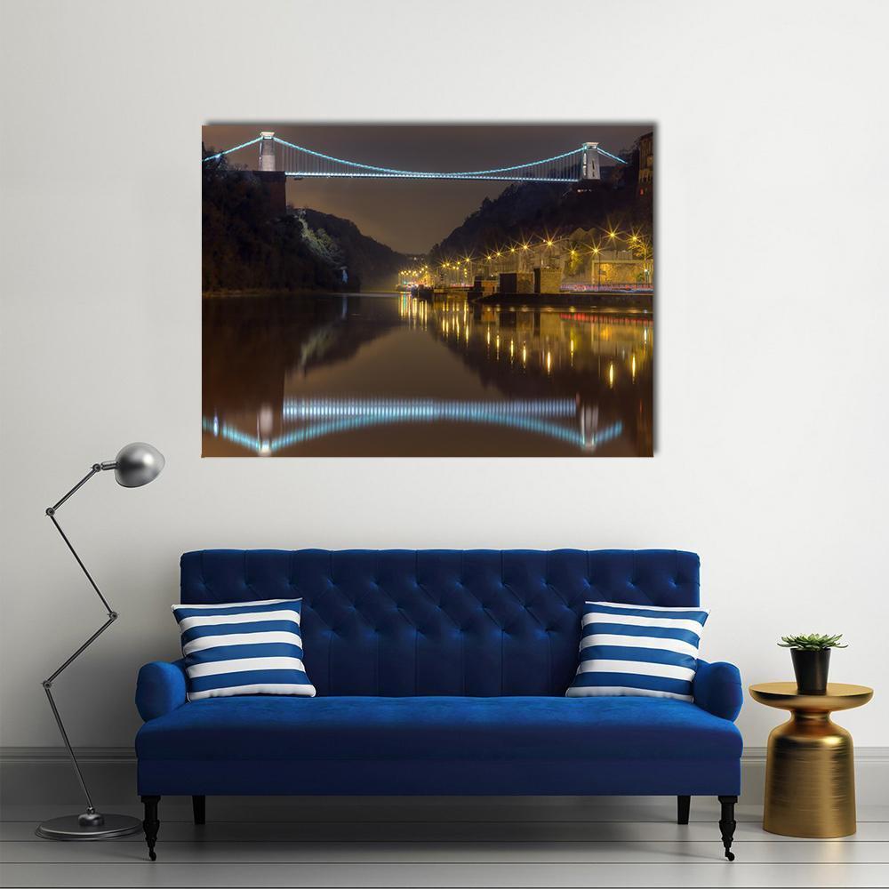 Illuminated Suspension Bridge at Night Canvas Wall Art in black, yellow and blue, single panel hung on a wall