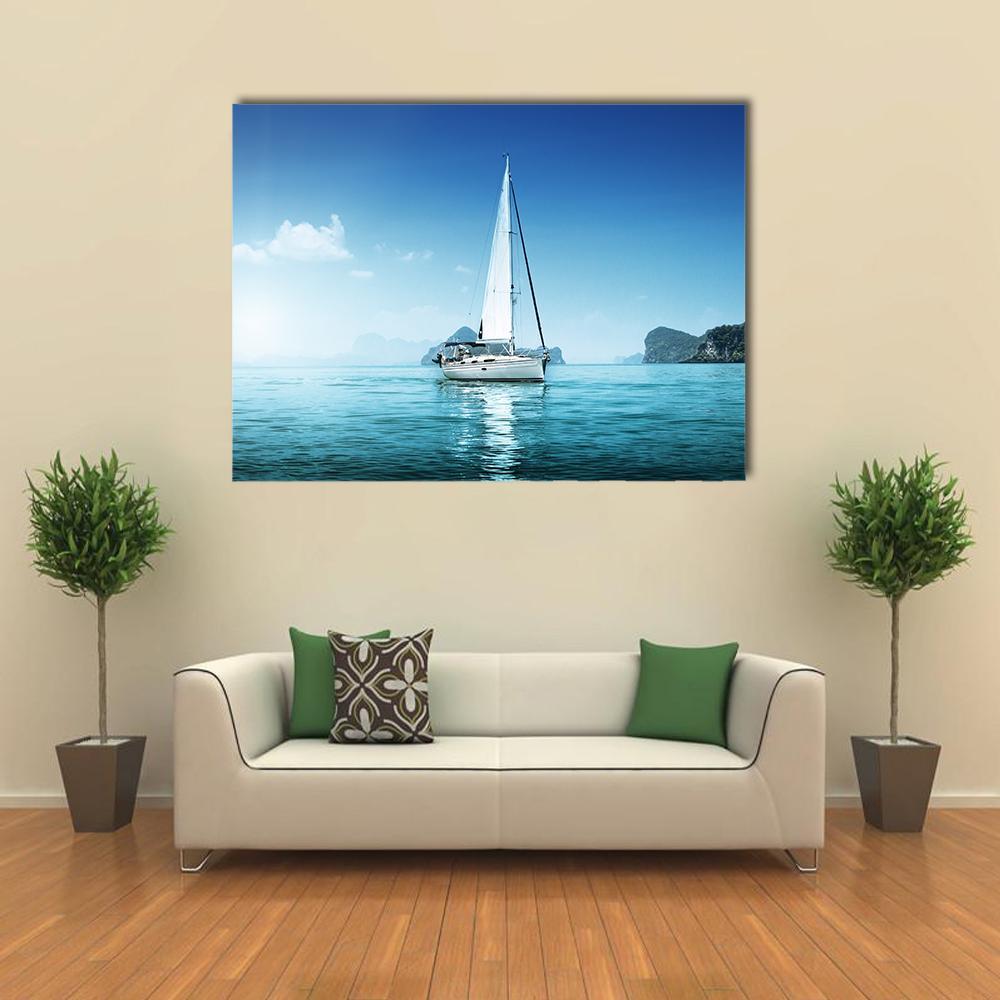 Single-masted Sailboat on Calm Blue Sea Canvas Wall Art in white and blue, single panel hung on a wall