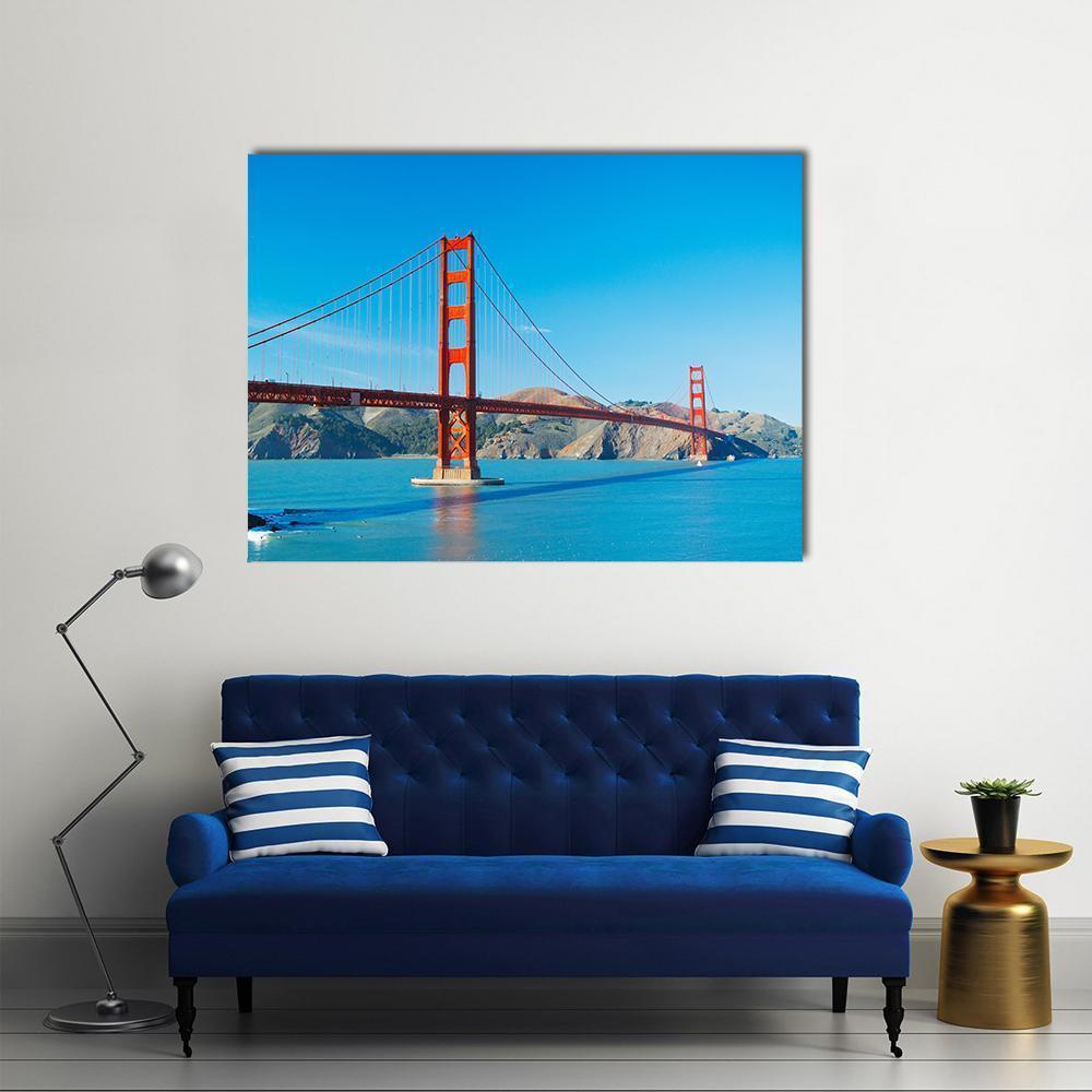Golden Gate Bridge Over San Francisco Bay Canvas Wall Art in orange and blue, single panel hung on a wall