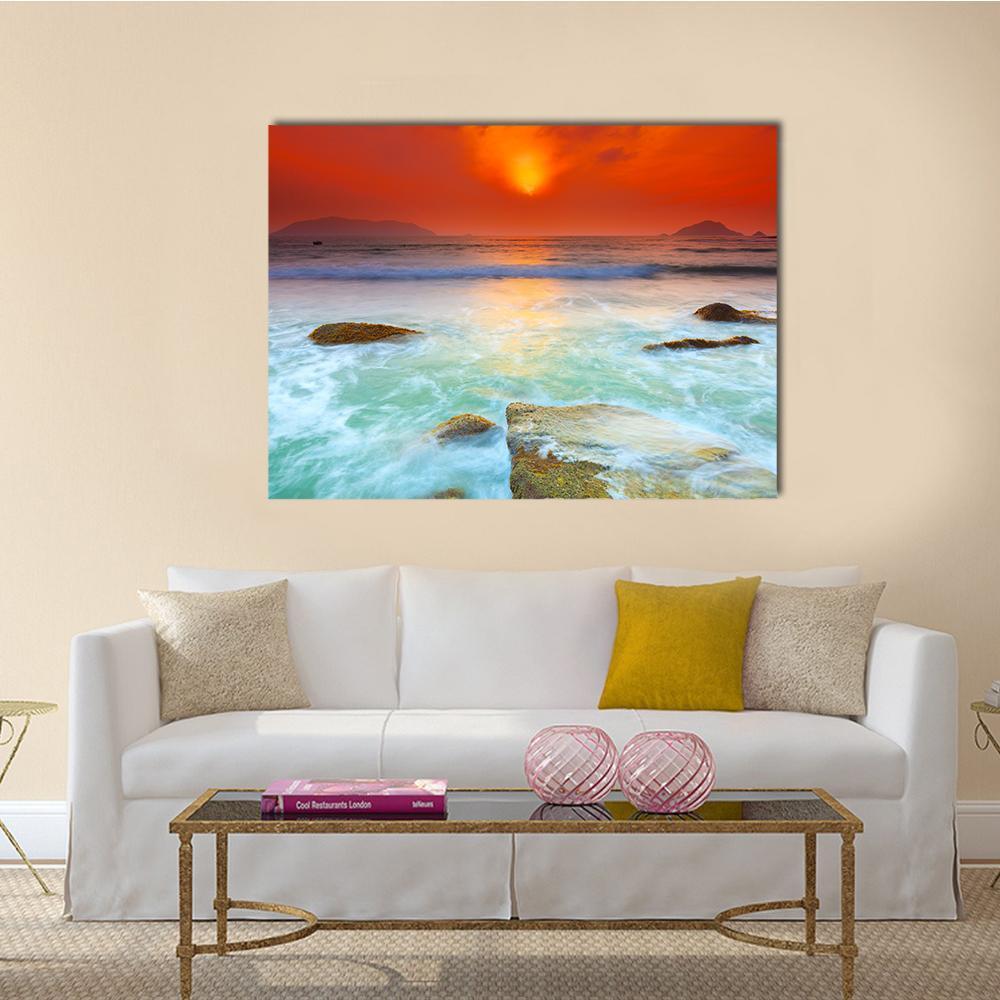 Sunrise Over the Sea Canvas Wall Art in orange, yellow and blue, single panel hung on a wall