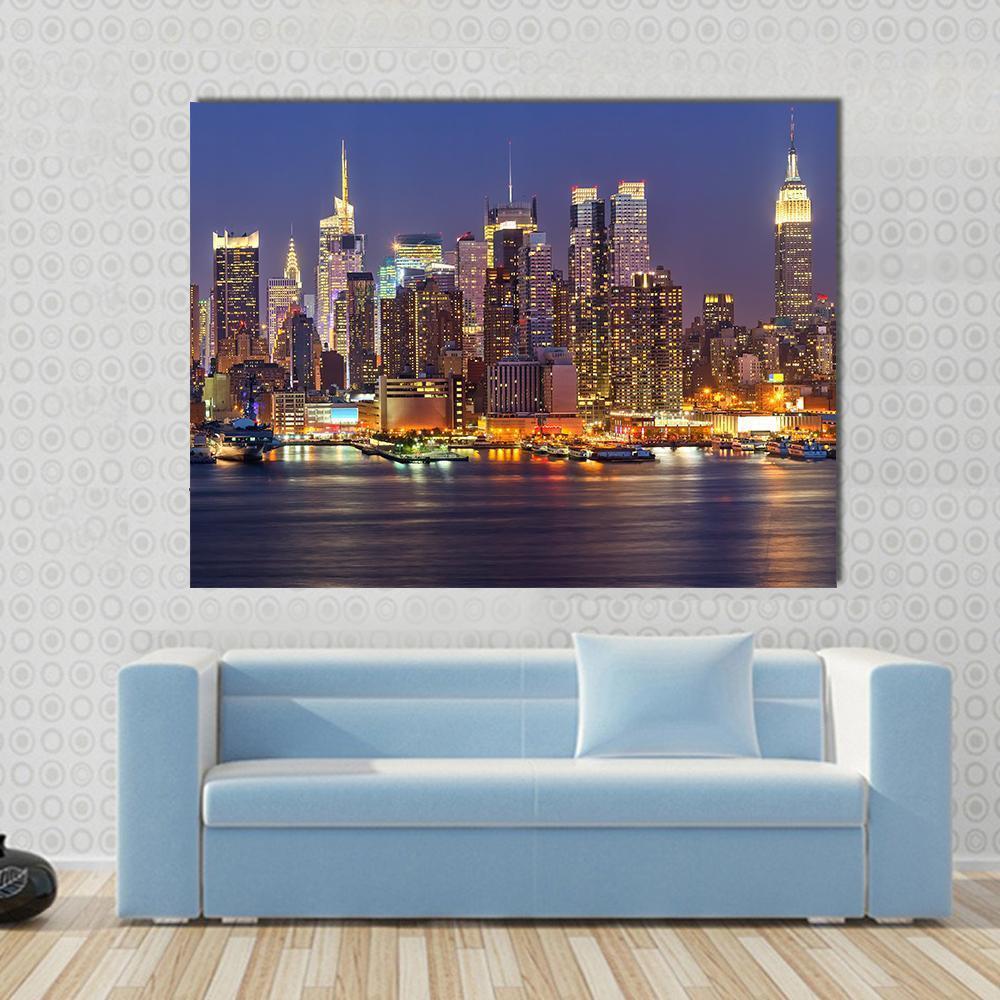 Manhattan Skyline at Night Canvas Wall Art in black, yellow and blue, single panel hung on a wall