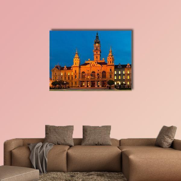 Gyor City Hall at Twilight Canvas Wall Art in orange, yellow and blue, single panel hung on a wall