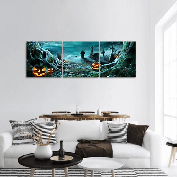 Glowing Jack-o'-lanterns in Misty Graveyard Panoramic Canvas Wall Art in black, orange and blue, hung on a wall