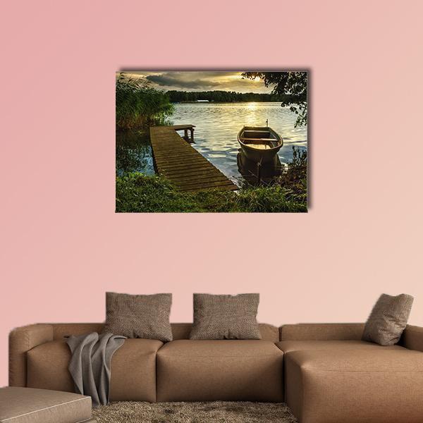 Lake Sunset with Pier and Rowboat Canvas Wall Art in brown, yellow and green, single panel hung on a wall