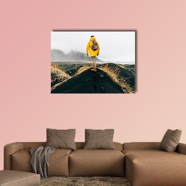 Hiker on Iceland Black Sand Dunes Canvas Wall Art in black, white and yellow, single panel hung on a wall